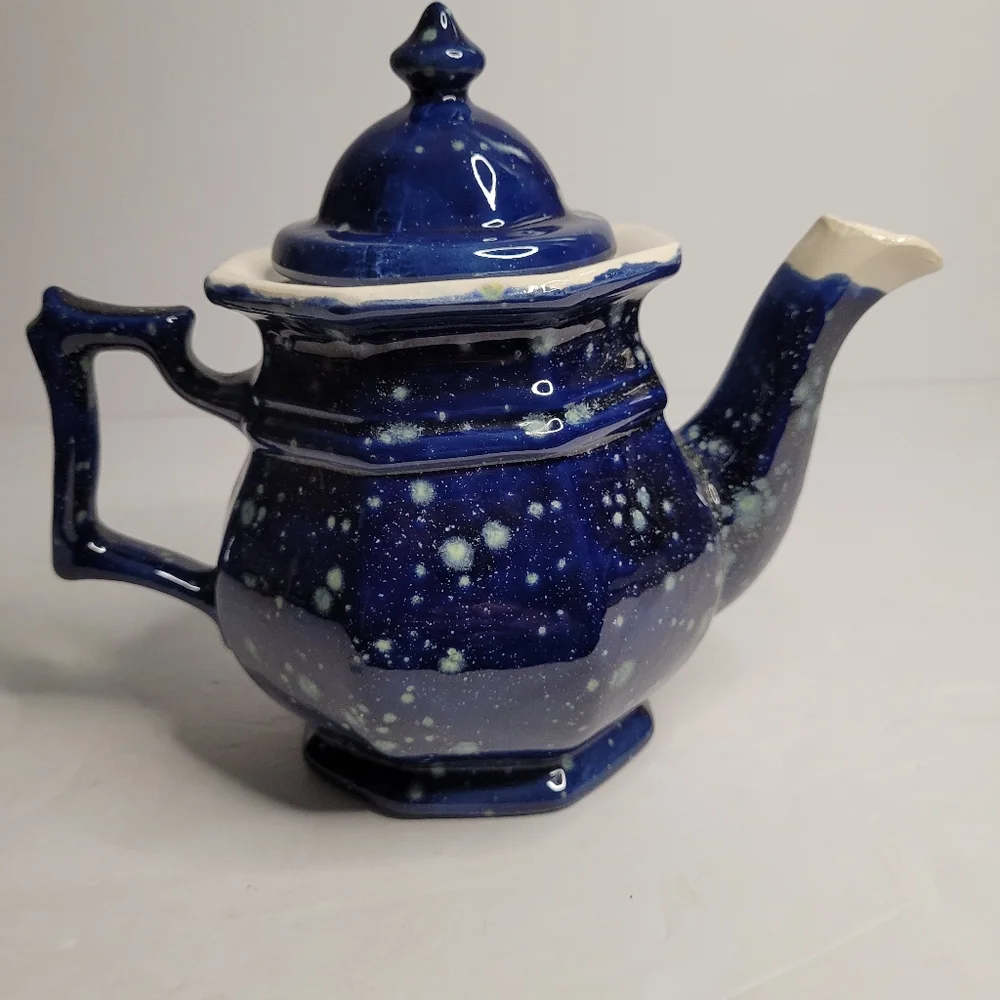 A blue and white speckled teapot. 271